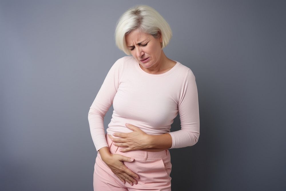 Mature woman with stomach pain adult anticipation midsection. AI generated Image by rawpixel.