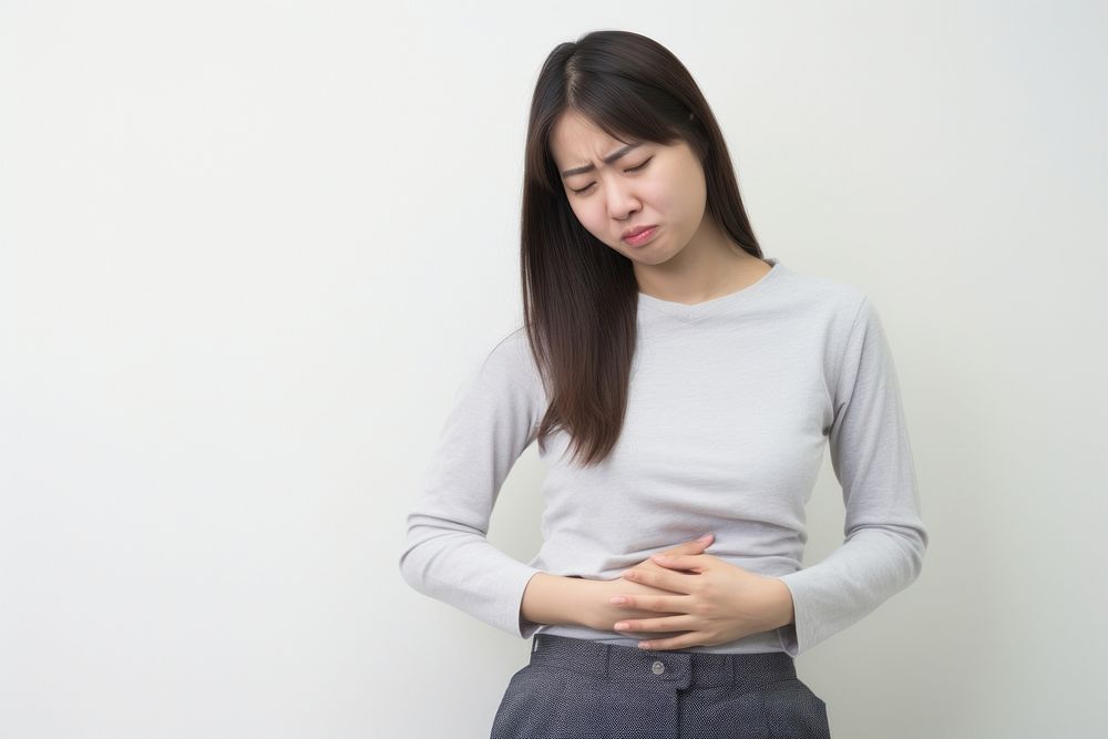 Girl with stomach pain cross-legged anticipation midsection. AI generated Image by rawpixel.