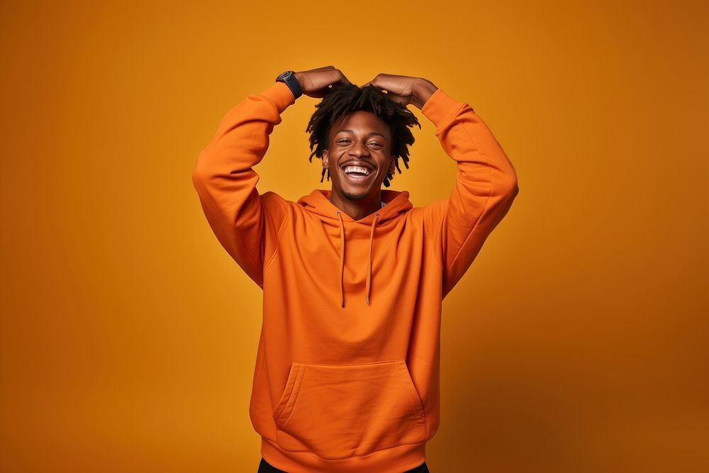 Young black man in sweatshirt with his arm up over his back head laughing happy triumphant. AI generated Image by rawpixel.