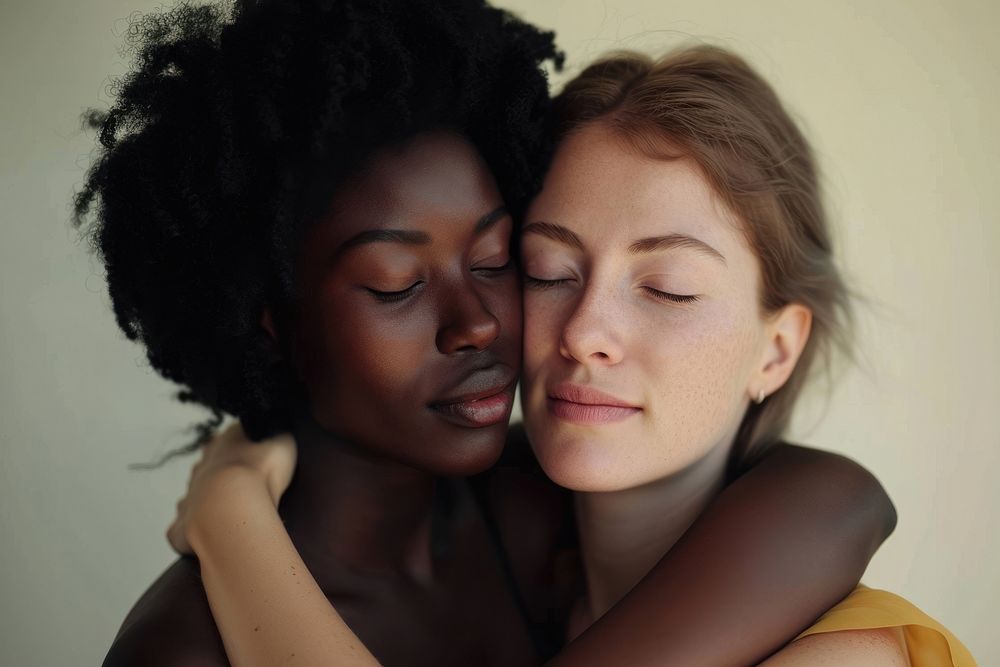 African woman and caucasian woman hugging portrait kissing.
