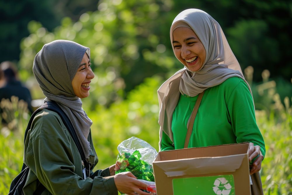 Muslim woman volunteer staff outdoors holding adult.