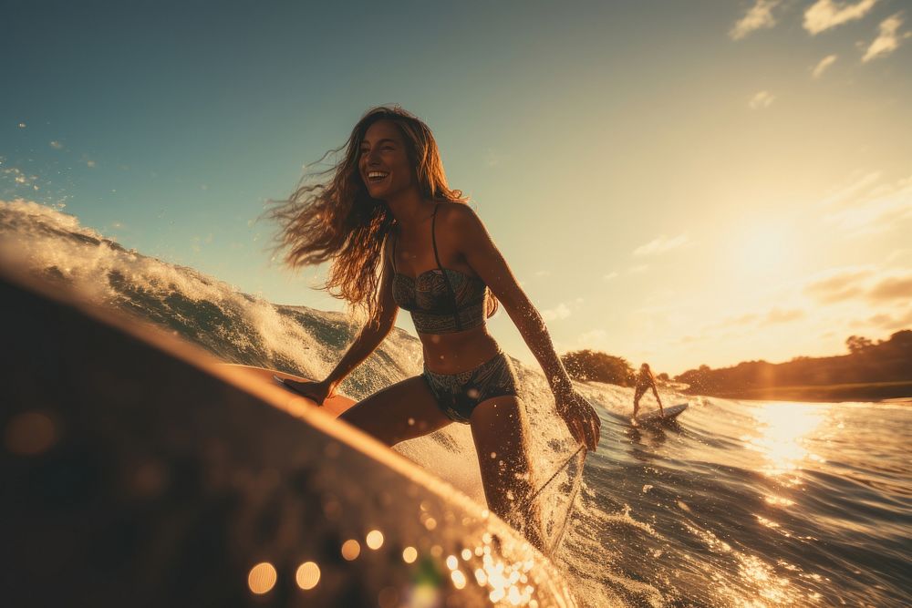 Young women wearing bodysuit on surfboard during a wave in the sea recreation swimwear outdoors.
