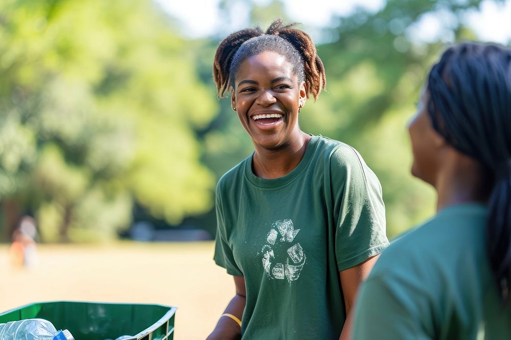Black woman volunteer staff laughing outdoors holding.