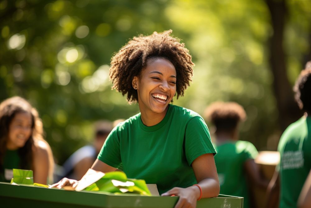 A black woman volunteer staff outdoors laughing smile.