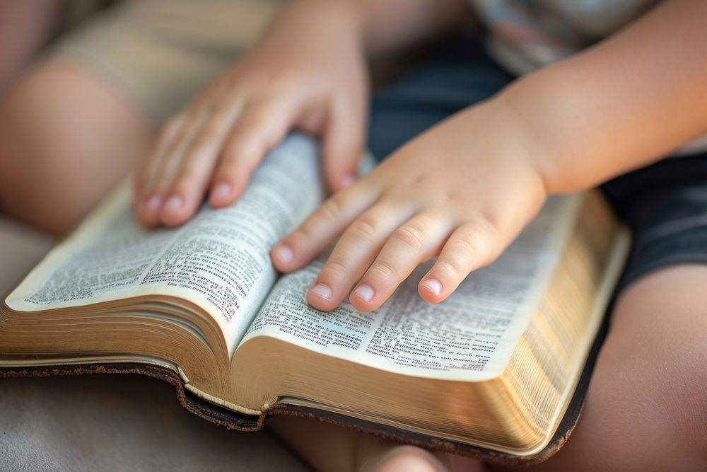 Two kid reading holy bible together publication hand book. 