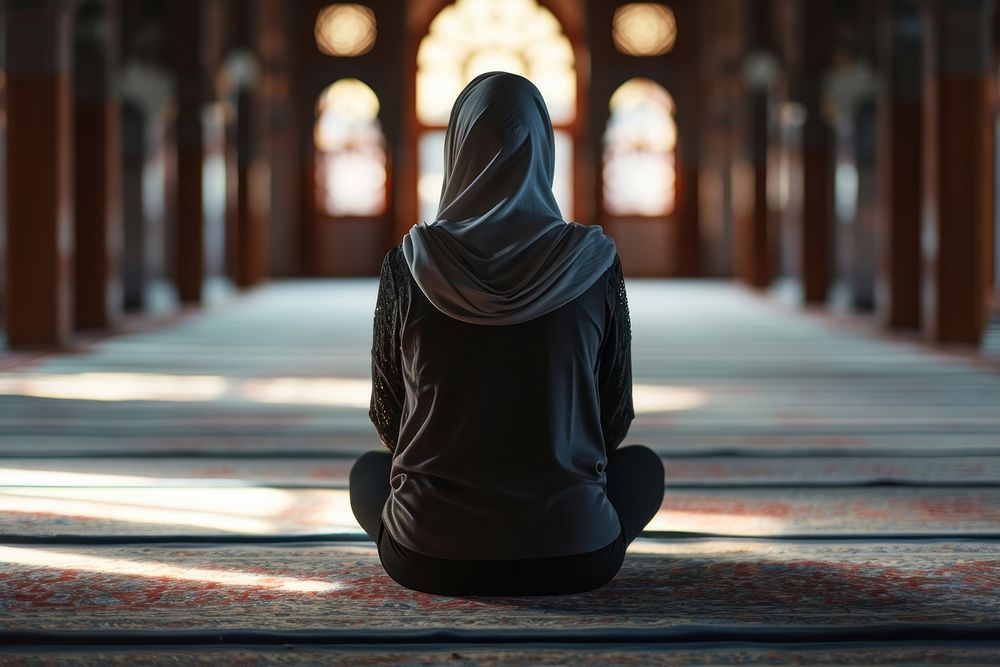 Muslim woman sitting and praying in Mosque adult cross-legged spirituality. AI generated Image by rawpixel.