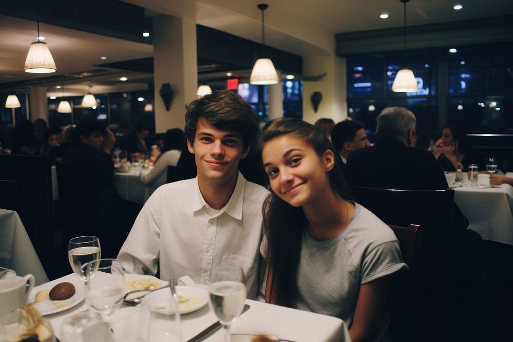 A teen couple dinner in a newyork restaurant portrait adult table.