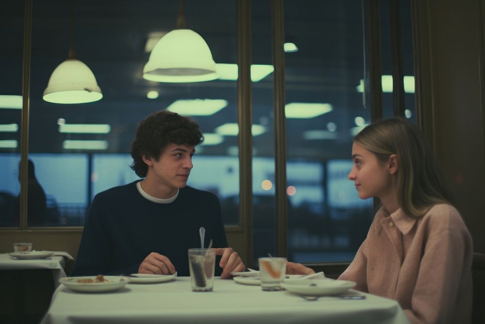 A teen couple dinner in a newyork restaurant conversation table food.