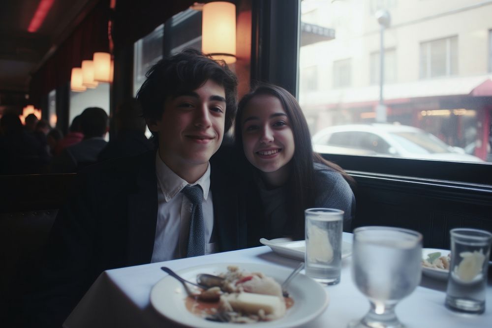 A teen couple dinner in a newyork restaurant architecture portrait glass.