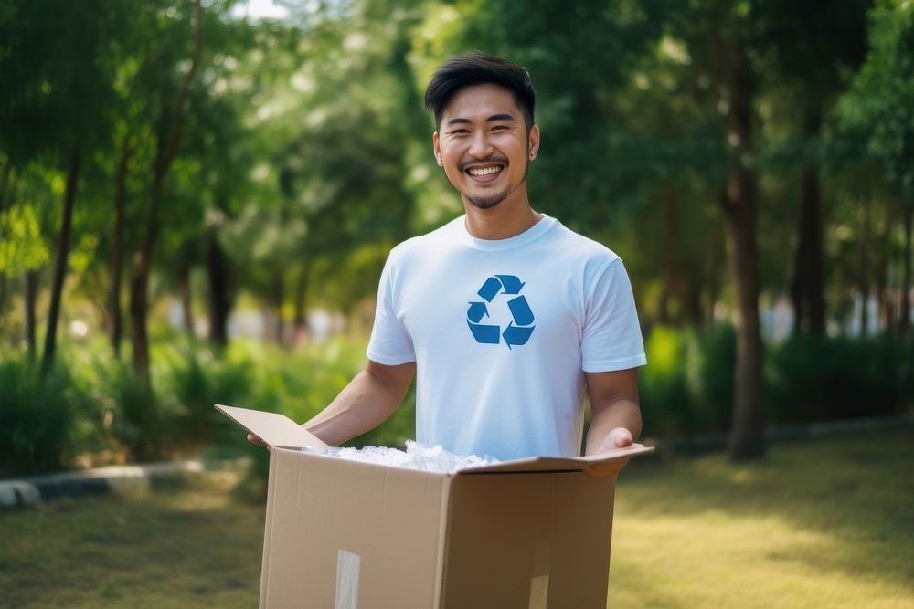 Asian man wearing clean t shirt box cardboard outdoors.