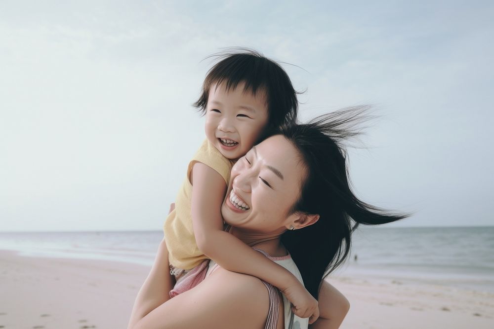 Asien mom piggyback baby on a beach photography portrait outdoors.