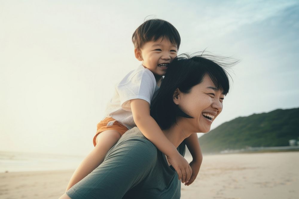 Asien mom piggyback baby on a beach photography outdoors portrait.