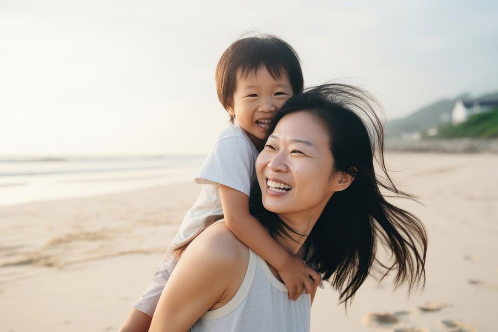 Asien mom piggyback baby on a beach photography portrait outdoors.