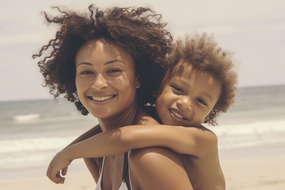 Black mom piggyback baby on a beach photography portrait outdoors.