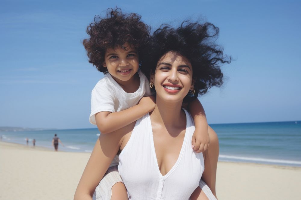 Indian mom piggyback baby on a beach photography laughing portrait.