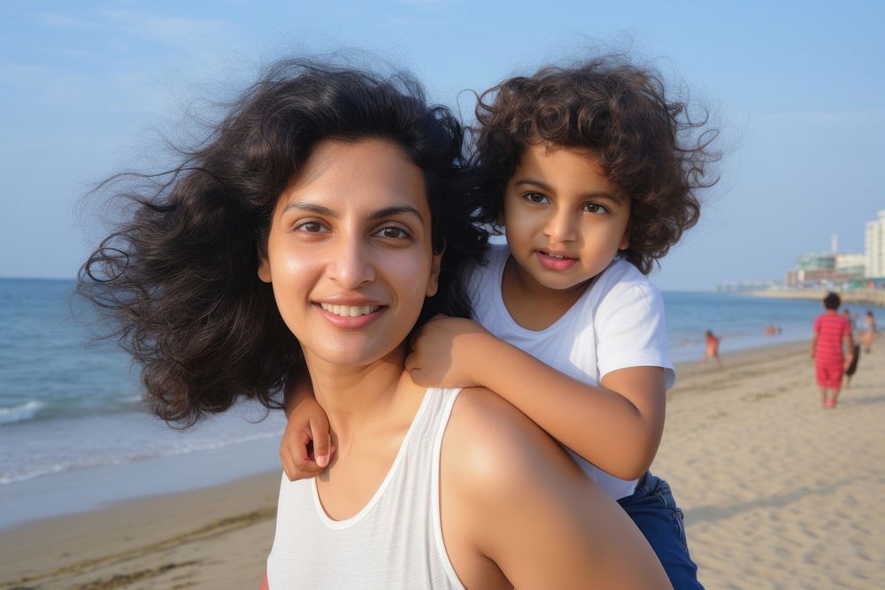 Indian mom piggyback baby on a beach photography portrait outdoors.