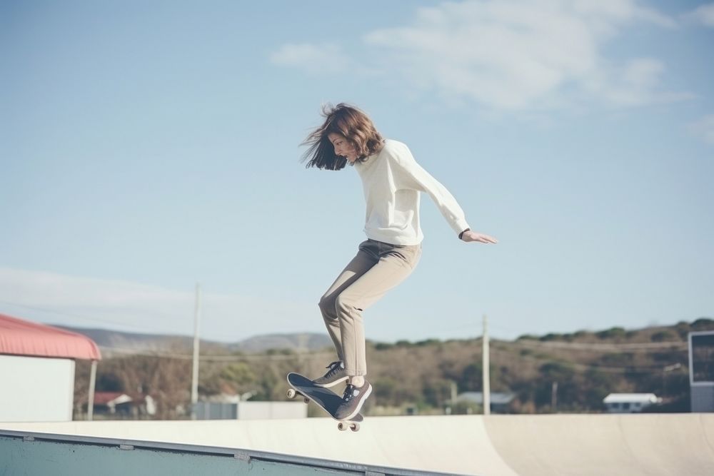 Skater girl jump and rides on skateboard at skate park jumping adult skateboarding.