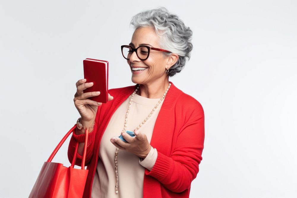 Young Hispanic senior woman buying shopping bags red white background photographing.