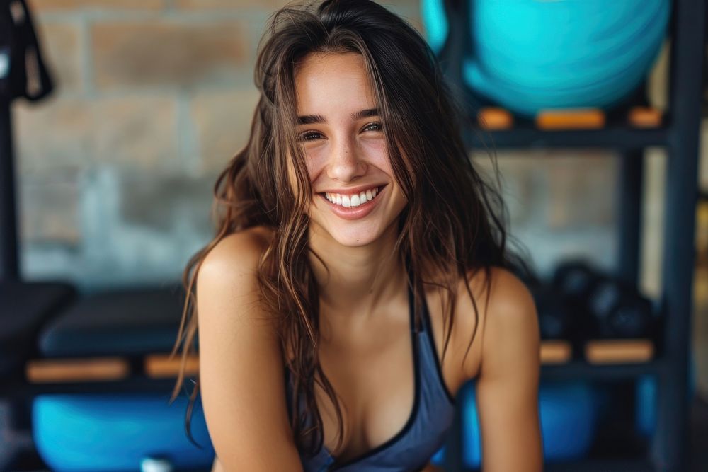 Young smiling woman having break after training at the gym smile determination bodybuilding.