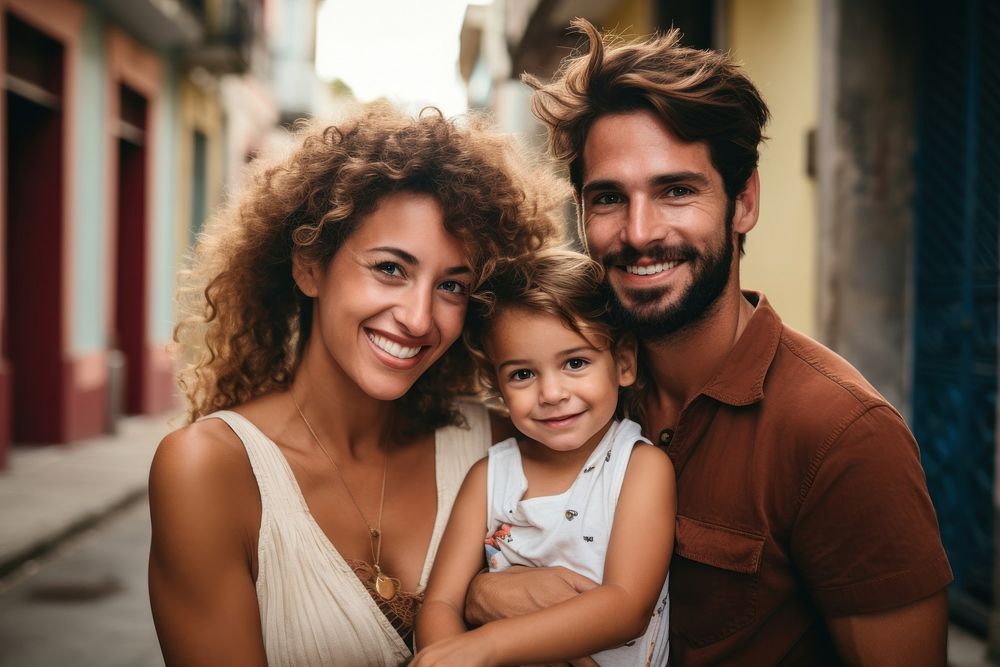 A Cuban family smiling together with their young child adult smile togetherness.