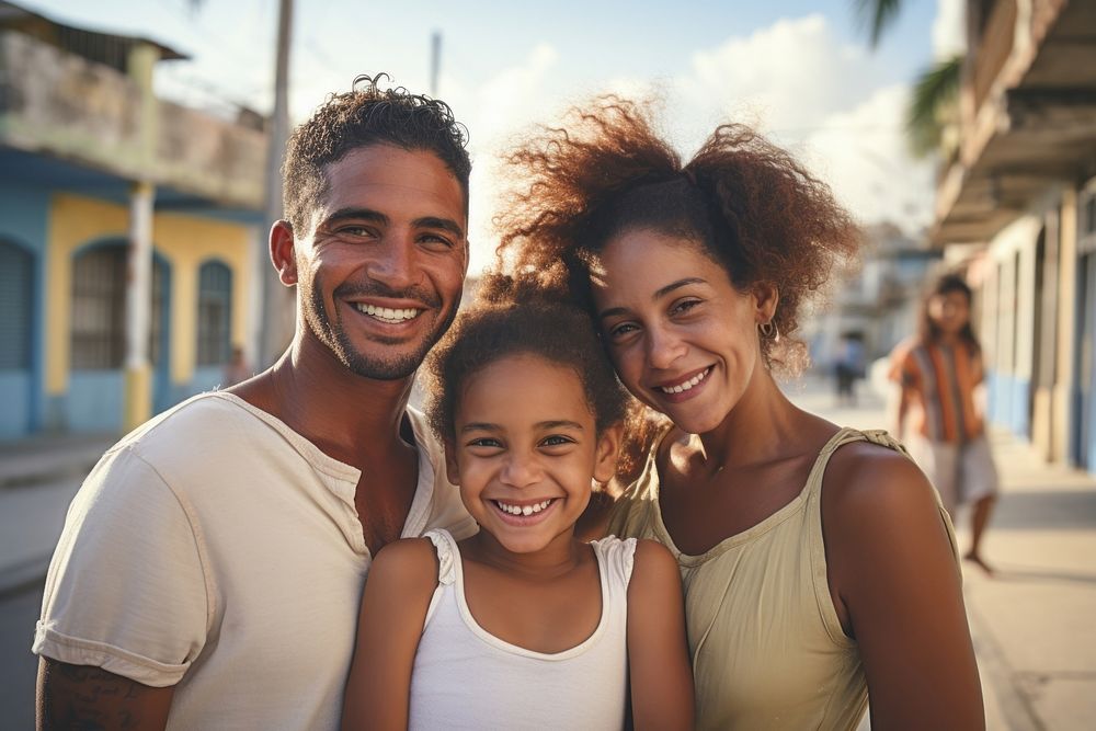 A Cuban family smiling together with their young child laughing adult smile.