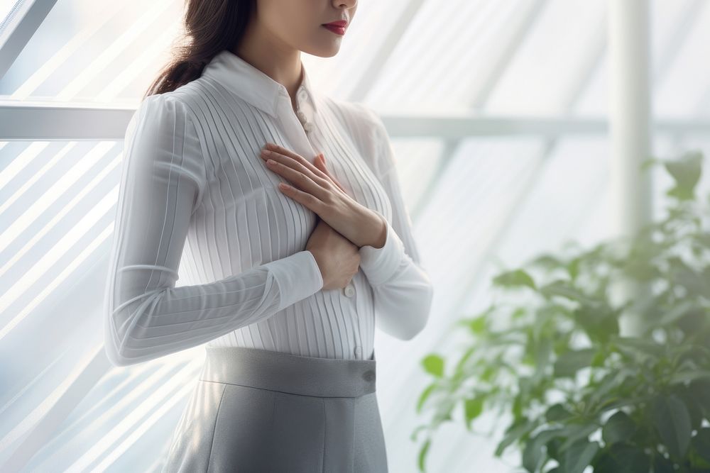 A women holding her hands on her chest and take a deep breath in morning blouse contemplation spirituality.