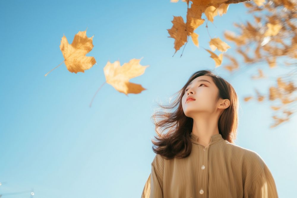 Asian woman holding and looking at fall leave sunlight plant adult. AI generated Image by rawpixel.