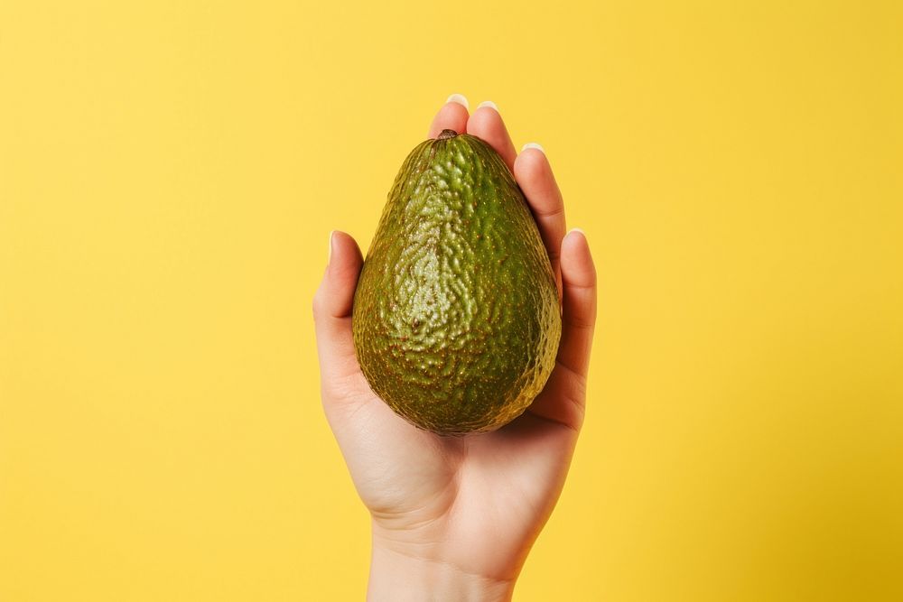 Hand holding fresh avocado fruit plant food. AI generated Image by rawpixel.