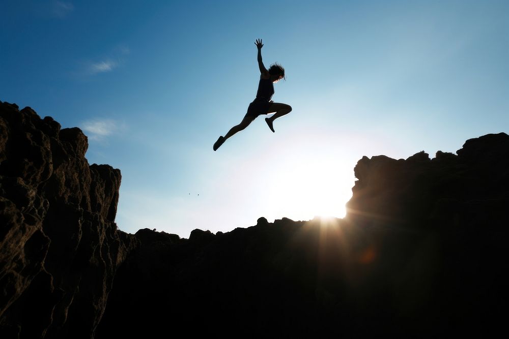 Person jumping from the cliff sky silhouette recreation. AI generated Image by rawpixel.