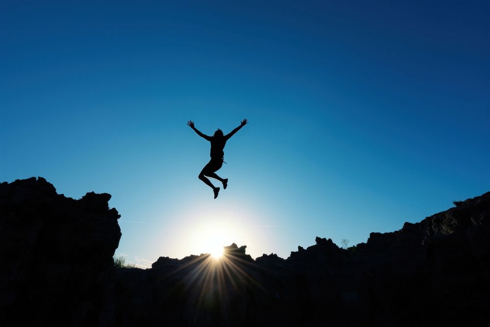 Person jumping from the cliff sky silhouette outdoors. AI generated Image by rawpixel.