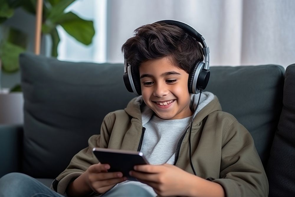 South Asian boy headphones listening computer. AI generated Image by rawpixel.