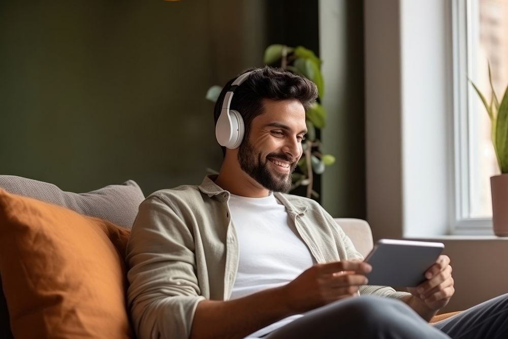 South Asian man headphones listening computer. AI generated Image by rawpixel.