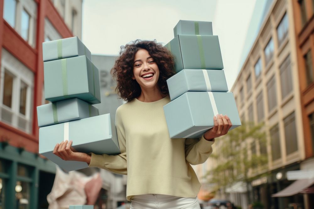 A joyful Latin woman with a stack boxes holiday smile adult.