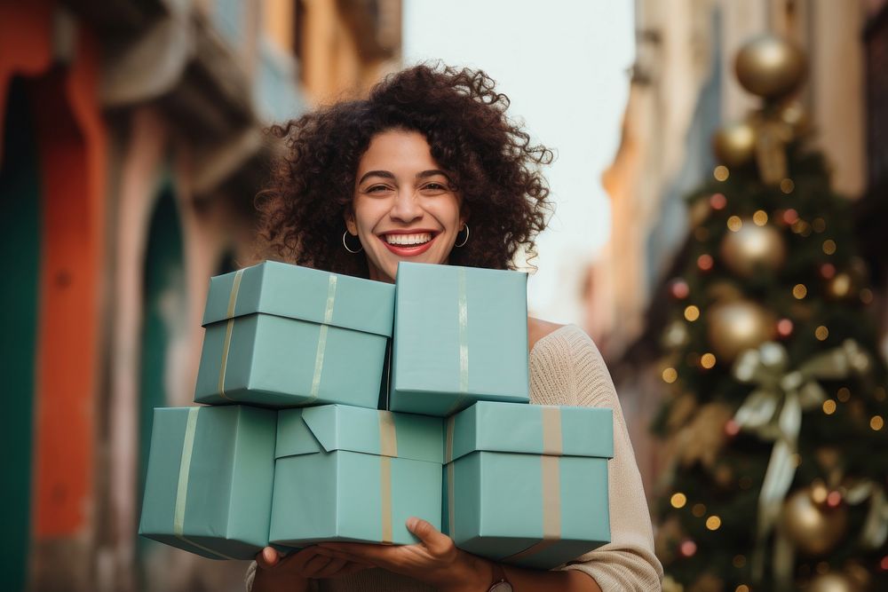 A joyful Latin woman with a stack boxes holiday adult anticipation.