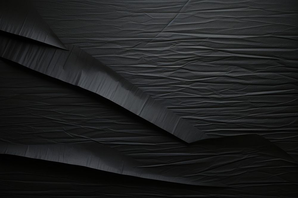 Folded black paper texture paper backgrounds bed monochrome.