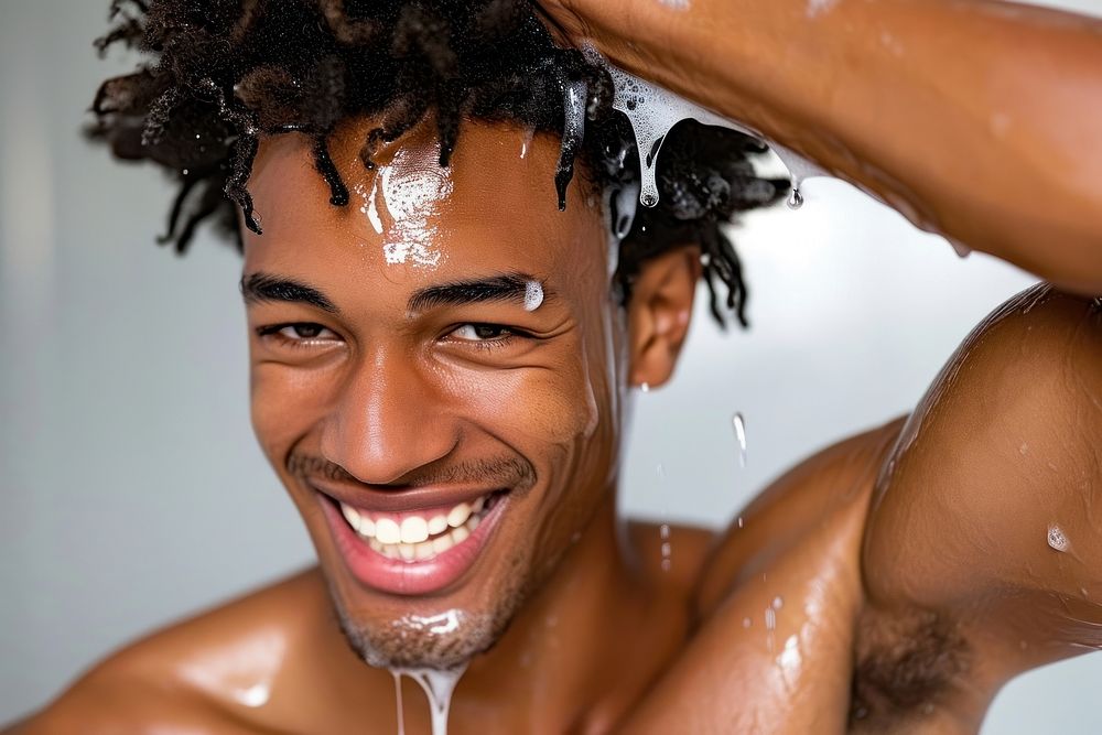 A happy black guy washing hair bathroom bathing bodybuilding.