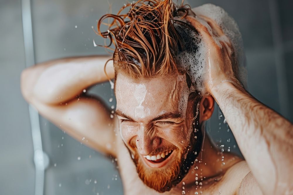 A happy guy washing hair bathroom shower hairstyle.