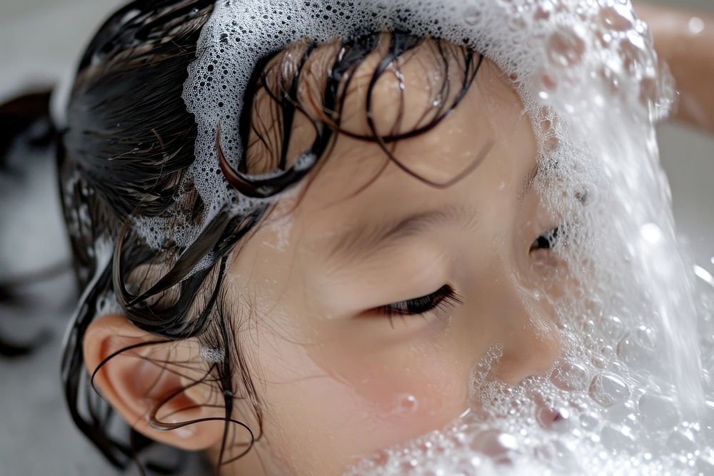 A happy kid washing hair portrait bathtub adult.