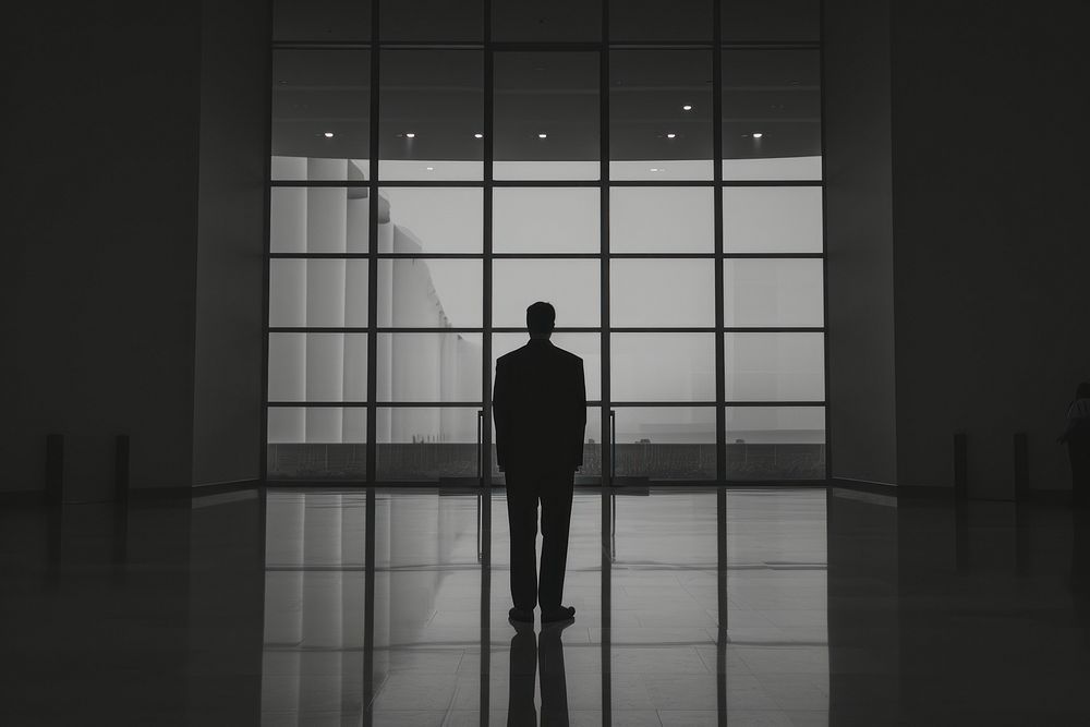 Sillhouette Black and white isolate business guy standing black architecture.