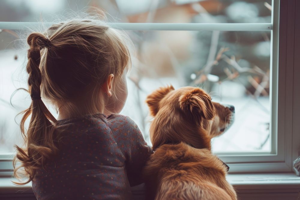 A girls with a dog looking out the window view mammal animal child.
