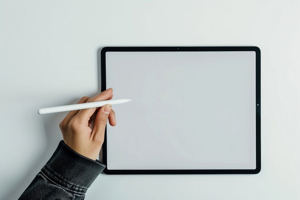 A hand holding a stylus on tablet technology creativity computer.