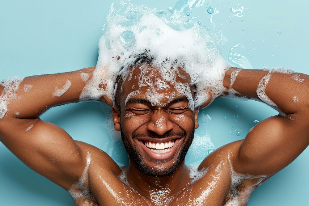 A happy black guy washing hair relaxation happiness enjoyment.