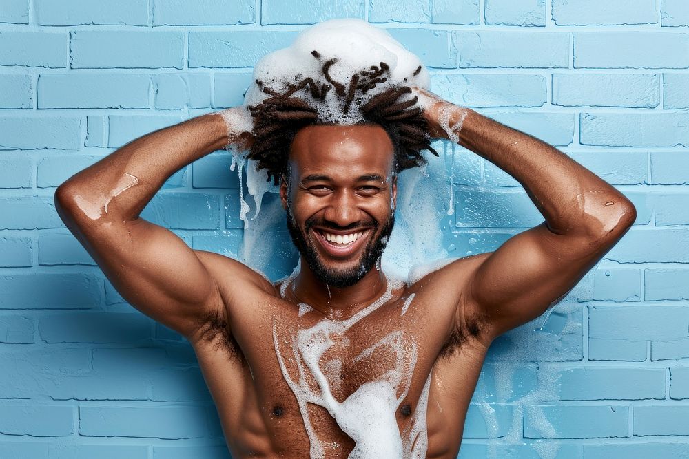 A happy black guy washing hair bathroom bodybuilding exercising.