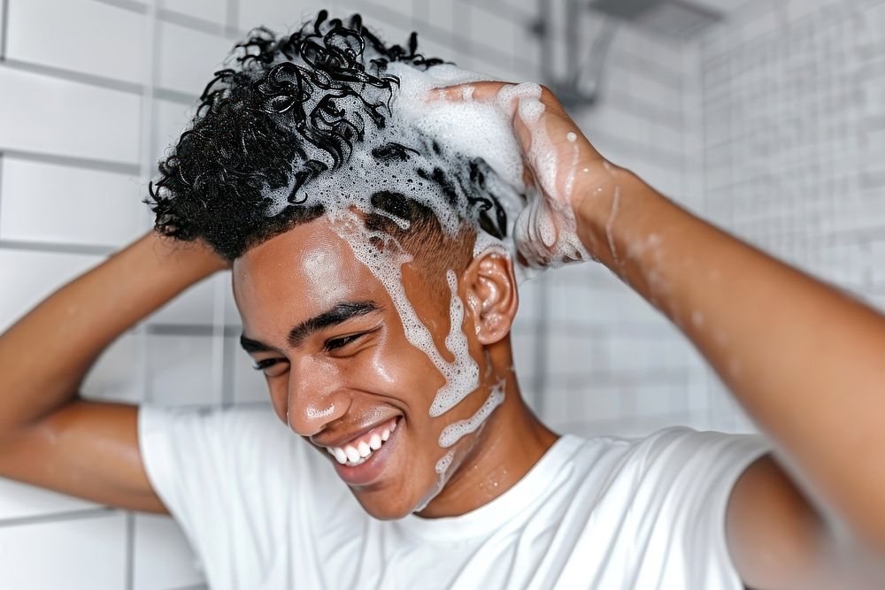 A happy black guy washing hair bathroom happiness enjoyment.