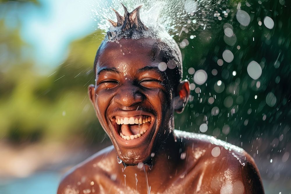 A happy black guy washing hair laughing bathing dreadlocks.