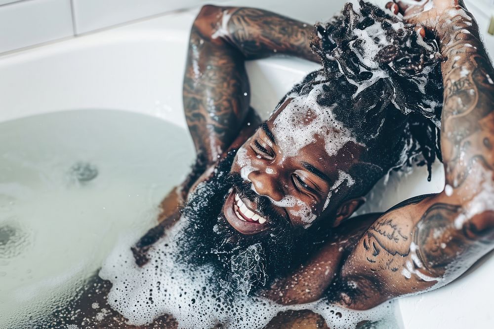 A happy black guy washing hair bathing adult enjoyment.