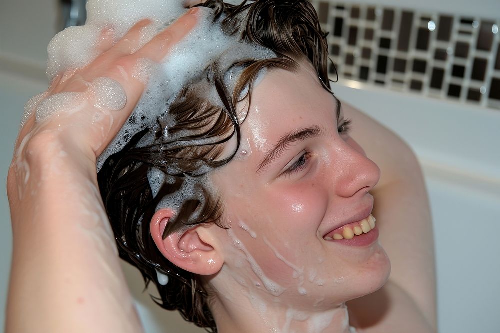 A happy guy washing hair bathing bathtub adult.