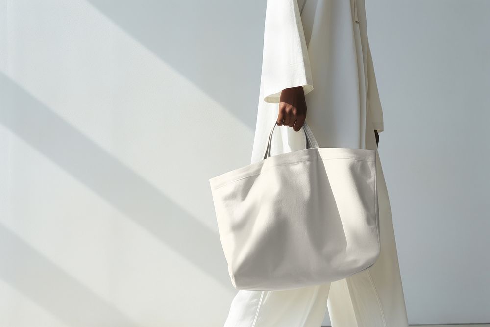 Woman holding white tote bag 