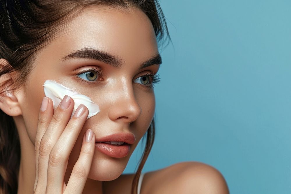 Woman applying skin face cream cosmetics adult cheek.