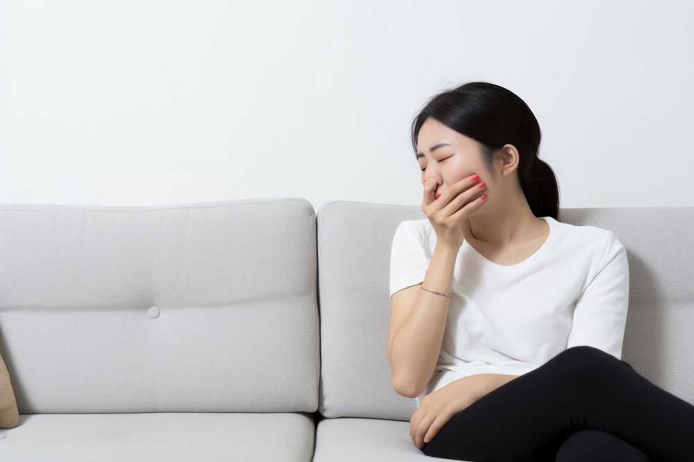 An east asian woman suffering from sickness furniture sitting adult.